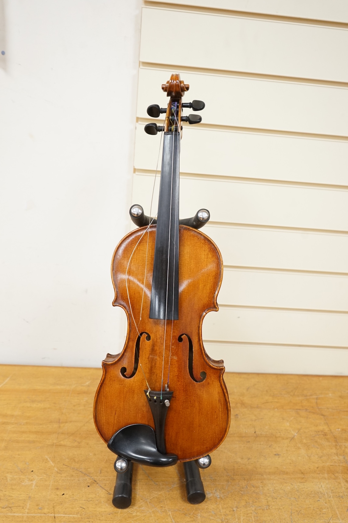 Three violins; a late 19th century German Stradivarius pattern violin, without label, a handmade violin (a.f.), with sound post crack, broken and repaired scroll, etc. and a Maidstone violin body, varnish stripped from t